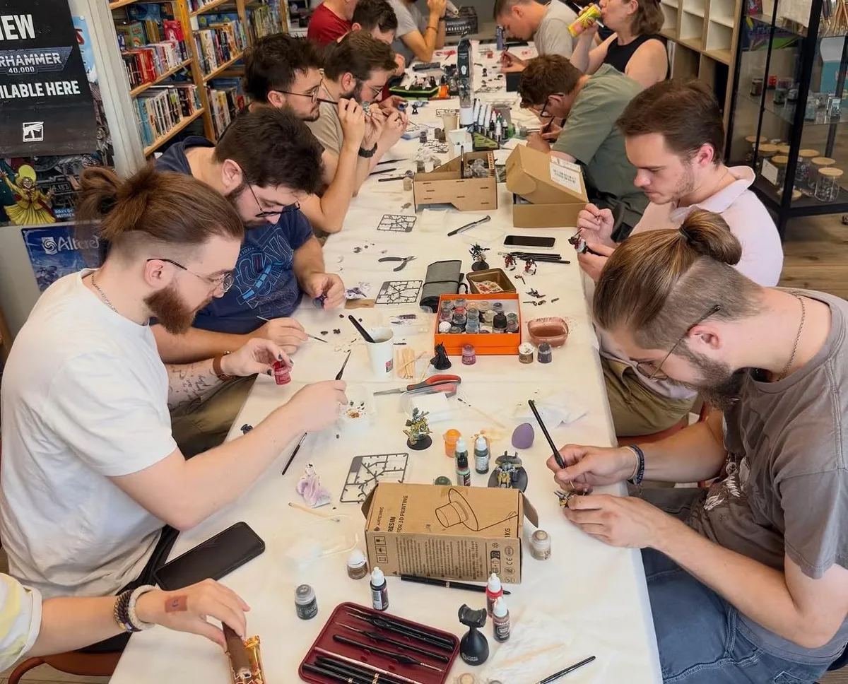 Atelier de peinture sur figurine à la boutique Lord of the Games : une grande tablée de participants peint des figurines Warhammer