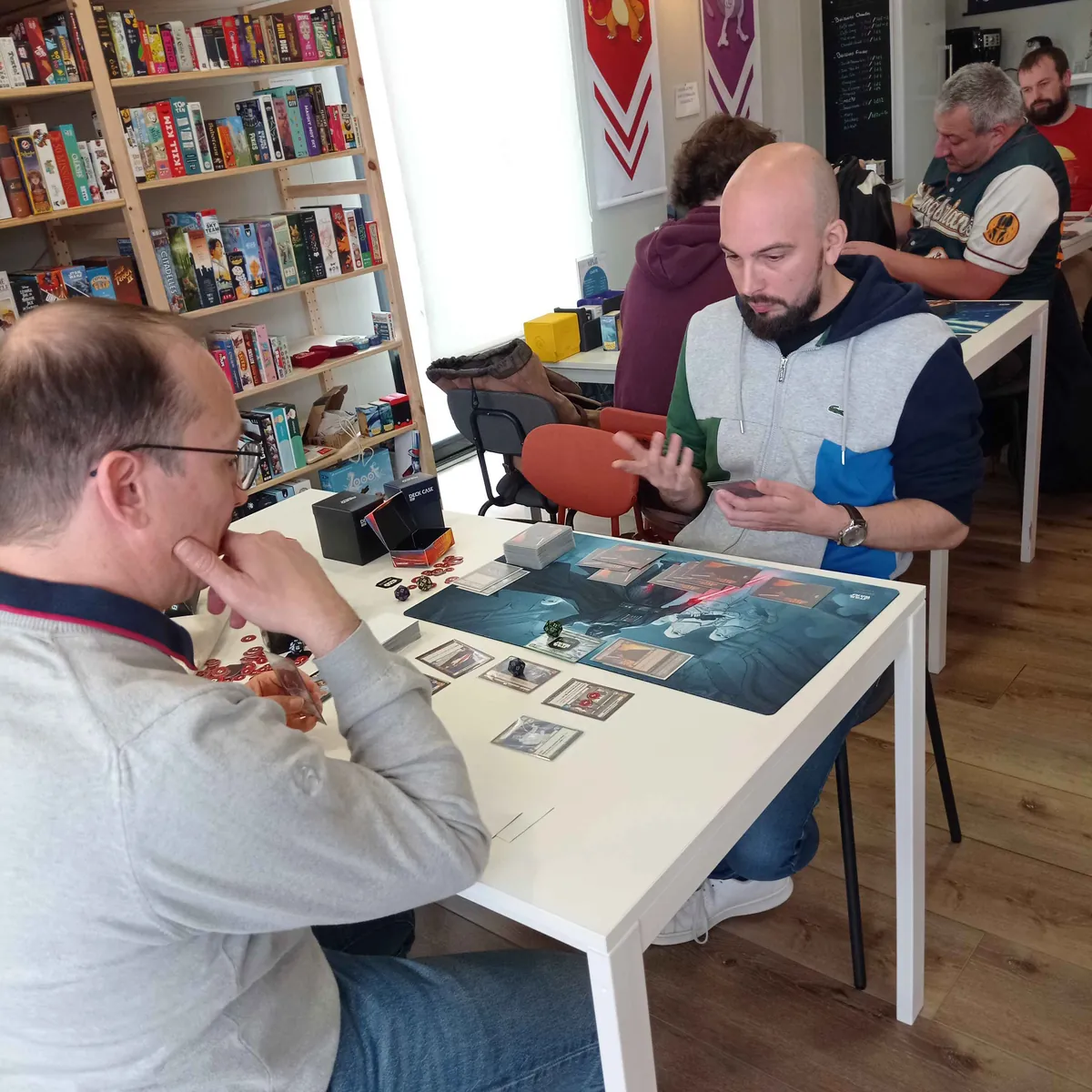 Joueurs en pleine partie aux tables du bar à jeux