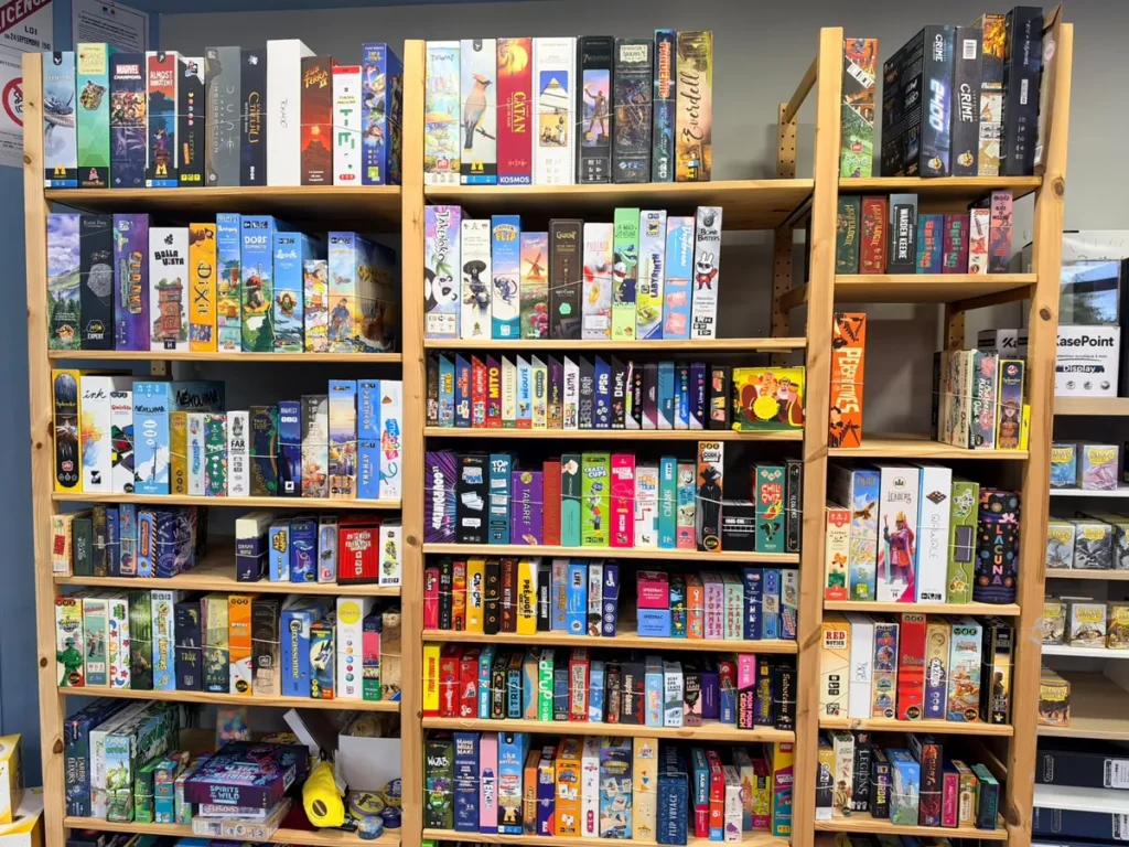 Étagères remplies de jeux de société de la ludothèque Lord of the Games, disponibles à la location