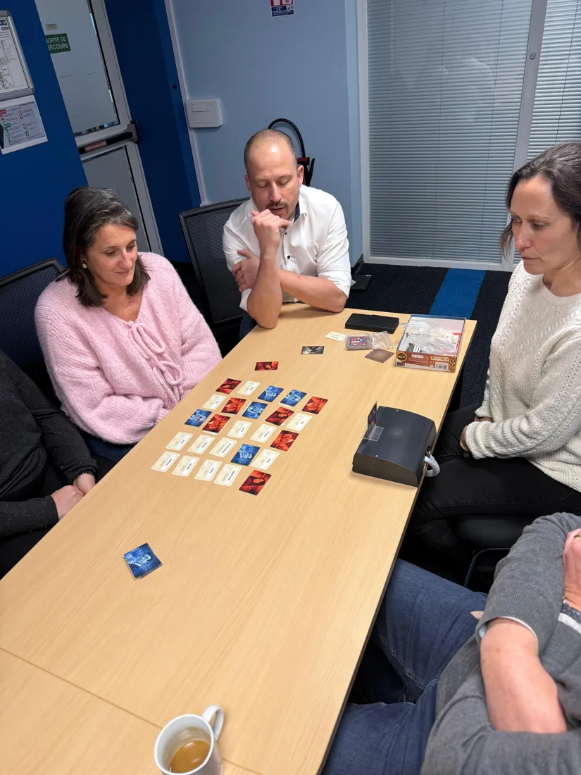 Team building en entreprise : des collègues réfléchissent autour d’une partie de Codenames